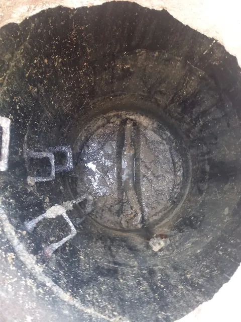 Wnętrze studzienki kanalizacyjnej pokryte osadem